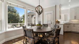 Large Dining room with space for long full table or quaint round table of your choice, dark wood finished floors, ornamental molding, and recessed lighting