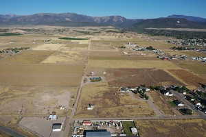 Aerial view of property and surrounding area featuring a mountainous background and rural landscape
