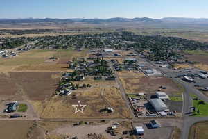 Aerial view of property and surrounding area featuring a mountain backdrop