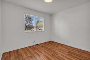 Main level bedroom featuring baseboards and wood finished floors