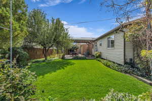 Fenced backyard featuring a pergola and a patio area