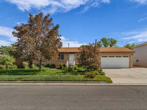 View of front of house with concrete driveway, an attached garage, RV parking and a shingled roof