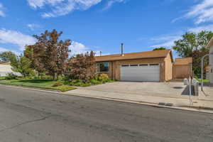 View of front of home with an attached garage, concrete driveway, and RV parking