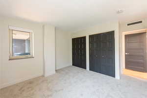 Unfurnished bedroom featuring two closets and carpet floors