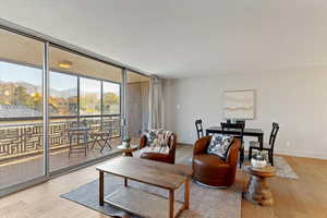 Living area with expansive windows, light wood finished floors, and a mountain view