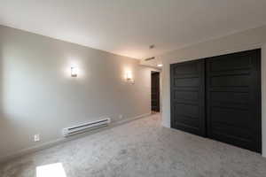 Carpeted cinema featuring baseboard heating and baseboards