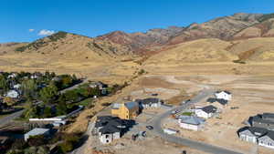 Aerial view of property's location featuring a mountain backdrop and nearby suburban area
