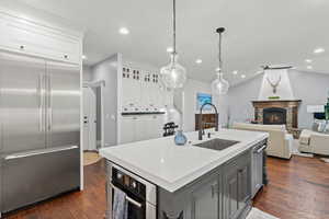 Kitchen featuring stainless steel appliances, open floor plan, dark wood finished floors, gray cabinetry, and white cabinetry