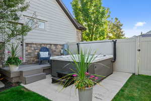 View of patio / terrace with a hot tub and a gate