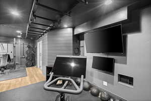 Workout room with wood finished floors, wood walls, and a textured ceiling