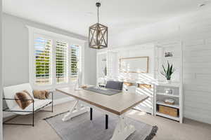 Office area with light carpet and wood walls