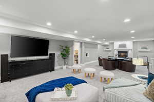 Living room featuring carpet floors, recessed lighting, and a glass covered fireplace