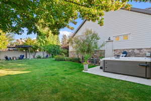 View of yard with a hot tub and a patio
