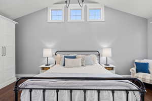 Bedroom featuring dark wood-style flooring and high vaulted ceiling