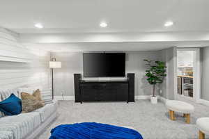 Carpeted living area featuring recessed lighting and beverage cooler