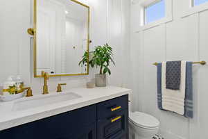 Half bathroom featuring vanity and toilet