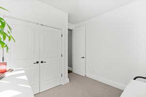 Bedroom featuring light carpet and a closet