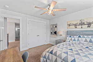 Bedroom with light carpet, a closet, and ceiling fan