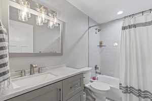 Bathroom with shower / tub combo with curtain, vanity, and recessed lighting