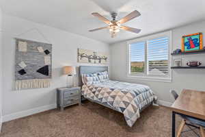 Carpeted bedroom with baseboards and ceiling fan