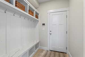 Mudroom featuring light wood-style flooring and baseboards
