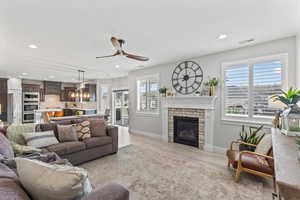 Living area with recessed lighting, light wood-type flooring, healthy amount of natural light, ceiling fan, and a fireplace