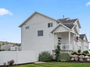View of front of property featuring board and batten siding, covered porch, and a residential view