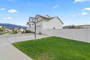 View of yard featuring driveway, a garage, a mountain view, and a residential view