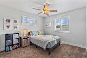 Bedroom with dark carpet and ceiling fan
