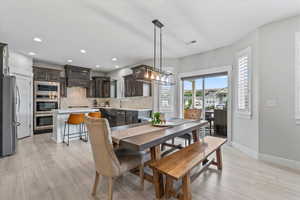 Dining area with light wood finished floors and recessed lighting