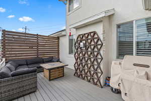 Wooden terrace featuring an outdoor living space with a fire pit