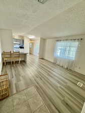 Unfurnished living room with a textured ceiling and light wood finished floors