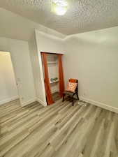 Unfurnished bedroom with a textured ceiling and light wood-type flooring