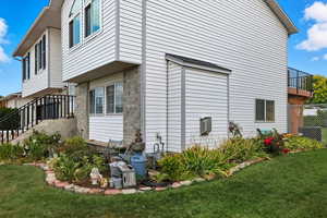 View of side of home with a lawn and brick siding