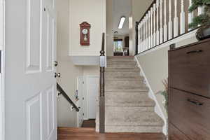 Stairway featuring wood finished floors