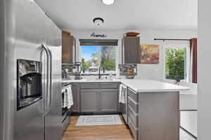 Kitchen with a peninsula, stainless steel appliances, light countertops, and tasteful backsplash