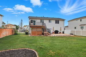 Rear view of property featuring a fenced backyard, stairway, a Trex deck, a patio, and a gate