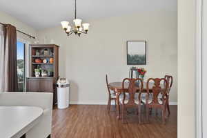 Dining space featuring wood finished floors and a chandelier
