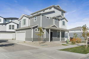 View of front of property featuring decorative driveway, covered porch, a garage, and board and batten siding