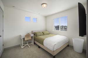 Bedroom featuring carpet and baseboards