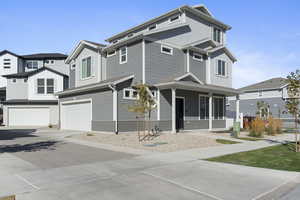 View of front facade with decorative driveway, a garage, covered porch, and board and batten siding