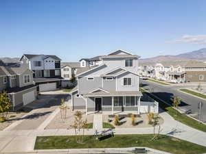 View of front of house with a residential view, decorative driveway, board and batten siding, a mountain view, and covered porch
