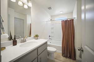Full bath with shower / bath combination with curtain, vanity, and light tile patterned floors