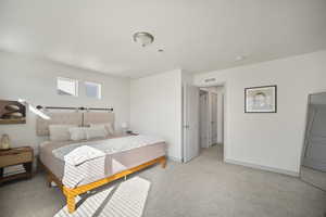 Bedroom with light carpet and baseboards