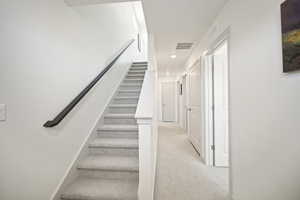 Staircase with carpet and recessed lighting