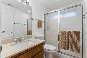 Bathroom featuring a shower stall & vanity