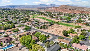 Aerial perspective of suburban area featuring mountains & nearby golf course