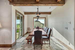Dining space featuring beamed ceiling and marble finish flooring