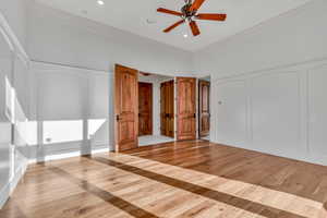 Unfurnished bedroom with light wood-type flooring, ornamental molding, ceiling fan, a decorative wall, and recessed lighting