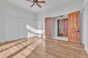 Unfurnished bedroom with light wood finished floors, ornamental molding, and a ceiling fan